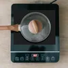 A close-up shot of a pot with a lid on an induction cooktop. Náhľad obrázku produktu