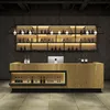 A modern bar counter with shelves stocked with bottles, illuminated by pendant lights. Produktbild-Vorschau