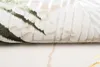 A close-up, rolled-up view of a carpet with a leaf-like pattern. Produktbild-Vorschau