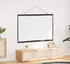 A white projection screen is mounted on a white wall above a wooden media console. Produktbild-Vorschau