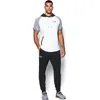 A man is standing and posing in athletic wear. Podgląd zdjęcia produktu