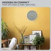 A modern living room setting with a clock on the wall and decorative items on a shelf. Náhled obrázku produktu