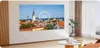 A projector is set up in a living room, projecting an image of a city skyline onto a wall. The room has modern furniture and decor. Anteprima dell’immagine prodotto