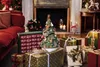 A Christmas scene with gifts, a decorative tree, and a fireplace. Podgląd zdjęcia produktu