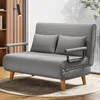 A grey sofa bed with two pillows is shown in a room with a bookshelf and a window. Anteprima dell’immagine prodotto