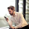 A man in a white shirt wearing a Bluetooth headset and looking at his phone. Produktbild-Vorschau