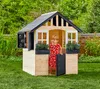 A young child is playing in a wooden playhouse in a garden. Náhled obrázku produktu