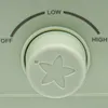 A close-up of a control knob on an appliance, showing settings for 'OFF', 'LOW', and 'HIGH'. Produktbild-Vorschau