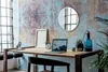A desk setup with a laptop, plant, and decorative items against a textured wall. Produktbild-Vorschau