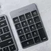 A close-up shot of a Satechi numeric keypad and part of a keyboard, placed on a textured gray surface. Voir les images du produit