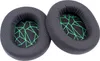 Two black ear pads with a green geometric pattern inside, placed on a white background. Náhled obrázku produktu
