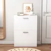 A white shoe cabinet with two drawers is shown in a room with a mirror and a door. Podgląd zdjęcia produktu