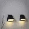 Two black solar wall lights mounted on a textured light gray wall. Produktbild-Vorschau