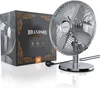 A chrome desk fan and its packaging are displayed on a reflective white surface. Produktbild-Vorschau