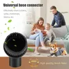 A family and a dog are relaxing on a couch in a living room, with a vacuum cleaner brush head prominently displayed in the foreground. Produktbild-Vorschau