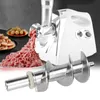 A white electric meat grinder is shown with ground meat coming out of it, and a close-up of a meat grinder screw is in the foreground. Plates of sausages and meatballs are in the background. Náhľad obrázku produktu