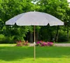 A patio umbrella is set up on a green lawn with a flower bed in the background. Produktbild-Vorschau