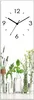 A vertical clock face with numbers and hands, superimposed over a row of glass vases containing various herbs and flowers. Produktbild-Vorschau