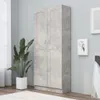 A tall, modern cabinet with two sets of double doors is shown in a room with light gray walls. A large potted plant with green leaves is on the left side of the cabinet, and framed artwork is on the right wall. A rug is visible in the foreground. Produktbild-Vorschau