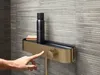 A hand is pressing a button on a shower fixture with a shelf holding a bottle and a brush. Produktbild-Vorschau