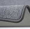 A close-up view of a gray carpet, showing the texture and edge binding. Anteprima dell’immagine prodotto