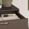 A close-up view of a brown poly rattan storage cabinet with books and scissors on a shelf. Anteprima dell’immagine prodotto