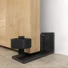 A close-up shot of a sliding door floor guide and hinge, mounted on a wooden door and a white wall. Náhľad obrázku produktu