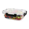 A clear glass food container filled with a variety of fresh fruits, including strawberries, blueberries, kiwi slices, grapes, and raspberries. The container has a transparent lid with black locking clips on the sides. Náhled obrázku produktu