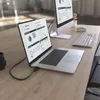 A laptop connected to an external monitor on a wooden desk, showing charts and graphs on both screens. Anteprima dell’immagine prodotto