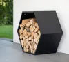 A black hexagonal log holder filled with firewood, placed on a patio next to a white wall. Podgląd zdjęcia produktu