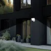 A modern black house with an LED exterior light illuminating the wall and a small garden area. Produktbild-Vorschau