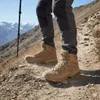 A person wearing hiking boots and pants walks on a mountain trail. Produktbild-Vorschau
