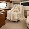 A cozy blanket draped over a chair inside a boat cabin. Náhled obrázku produktu