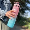 A person holding a pink and blue gradient water bottle with time markings. Produktbild-Vorschau