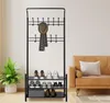 A coat rack with shoe shelves in a room with a couch and a plant. Produktbild-Vorschau
