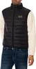 A man wearing a black puffer vest over a cream-colored long-sleeved shirt and blue jeans. Produktbild-Vorschau