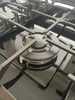 A close-up view of a gas stove burner and grate. Produktbild-Vorschau