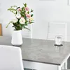 A dining table set with a vase of flowers and a glass of water. Voir les images du produit