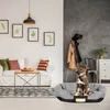 A dog is sitting in a dog bed in a living room with a sofa and decor. Anteprima dell’immagine prodotto