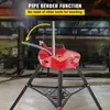 A red pipe bender mounted on a black tripod stand, with a metal pipe being bent. The background appears to be a workshop or industrial setting. Náhled obrázku produktu