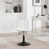 A white tufted chair with a black base is shown in a room with a desk and shelves. Produktbild-Vorschau
