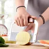 A person is using a wavy-edged knife to cut a potato. Produktbild-Vorschau