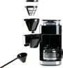 An exploded view of a coffee maker, showing its various components laid out separately, with a measuring scoop in the foreground. Podgląd zdjęcia produktu