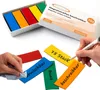 A box of colorful magnetic strips and several strips laid out with hands writing on them and cleaning one. Náhled obrázku produktu