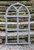 A gray cast iron window frame with gothic arches and multiple panes, placed on a stone staircase. Produktbild-Vorschau