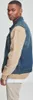 A man wearing a denim vest with tan sleeves. Produktbild-Vorschau