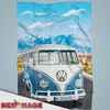 A Volkswagen Bulli T1 van on a road with mountains and sky in the background. Produktbild-Vorschau
