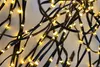A close-up view of a tangled string of black wires with small, bright yellow LED lights. Produktbild-Vorschau