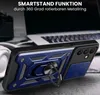 A close-up of a blue and black phone case with a ring stand, placed on a textured surface with a blurred laptop and headphones in the background. Produktbild-Vorschau