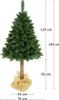 A green artificial Christmas tree with a brown trunk, standing on a burlap base. Dimensions are indicated with measurement lines and text. Náhľad obrázku produktu